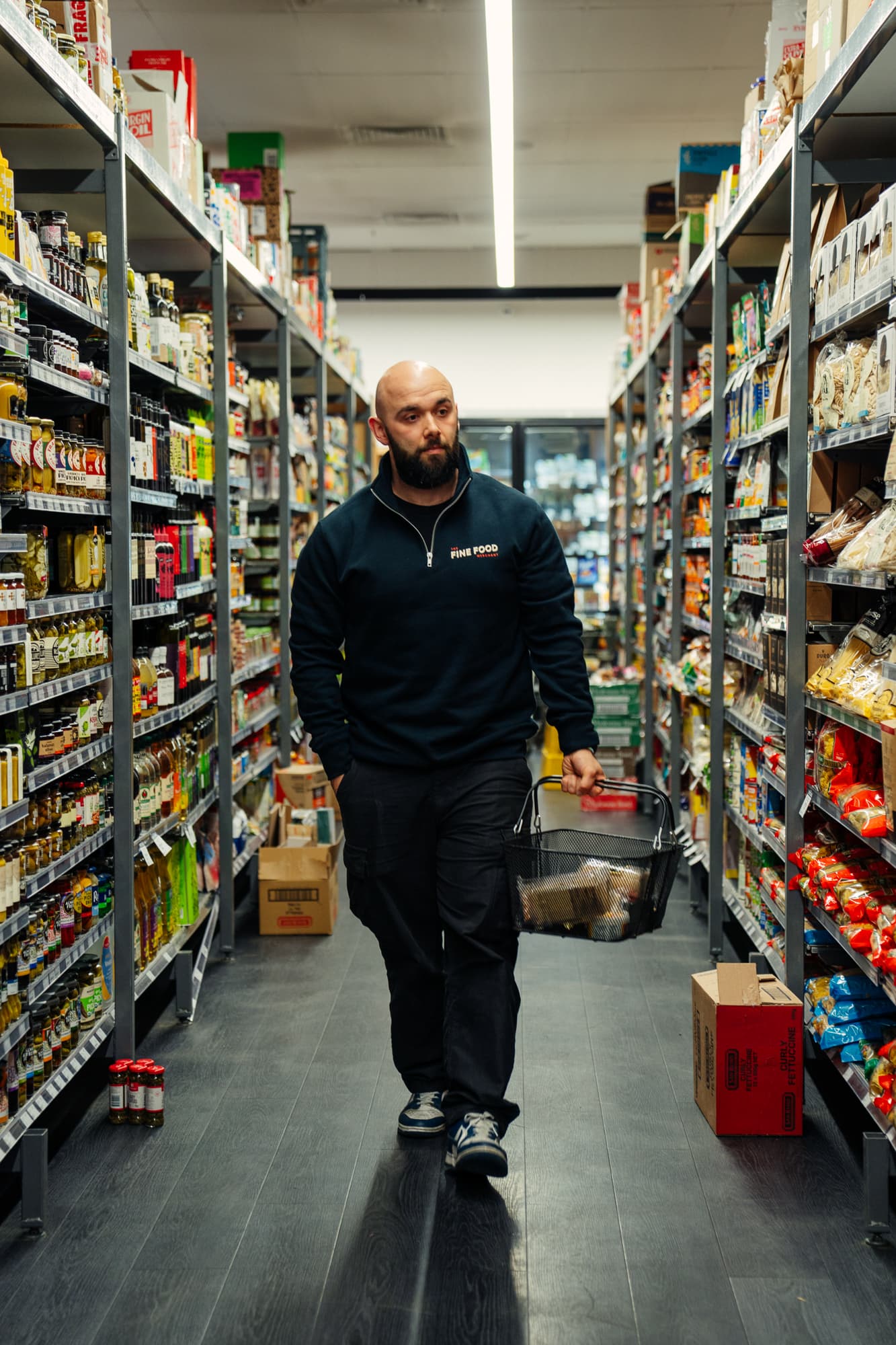Fine Food Merchant Owner walking down the aisle of a supermarket